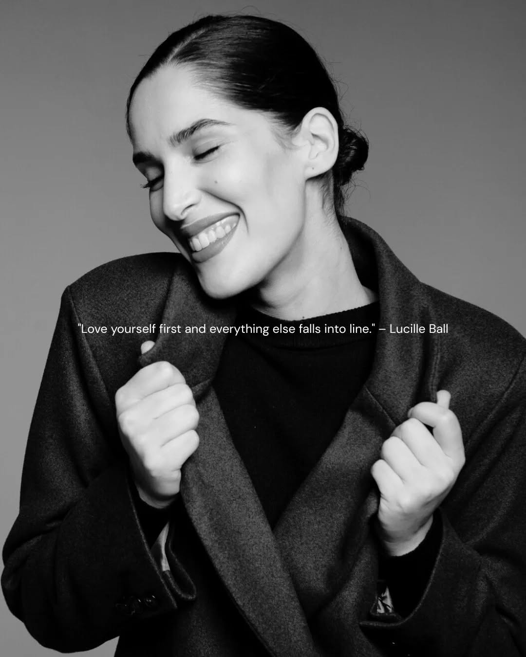 Portrait en noir et blanc d'une femme souriante avec un manteau, citant Lucille Ball sur l'amour de soi.